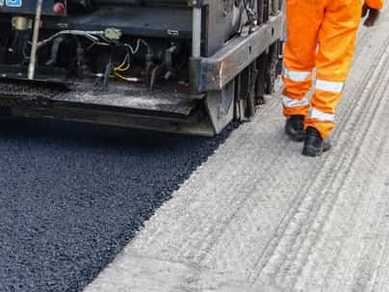 new asphalt layer being laid in parking lot resurfacing job